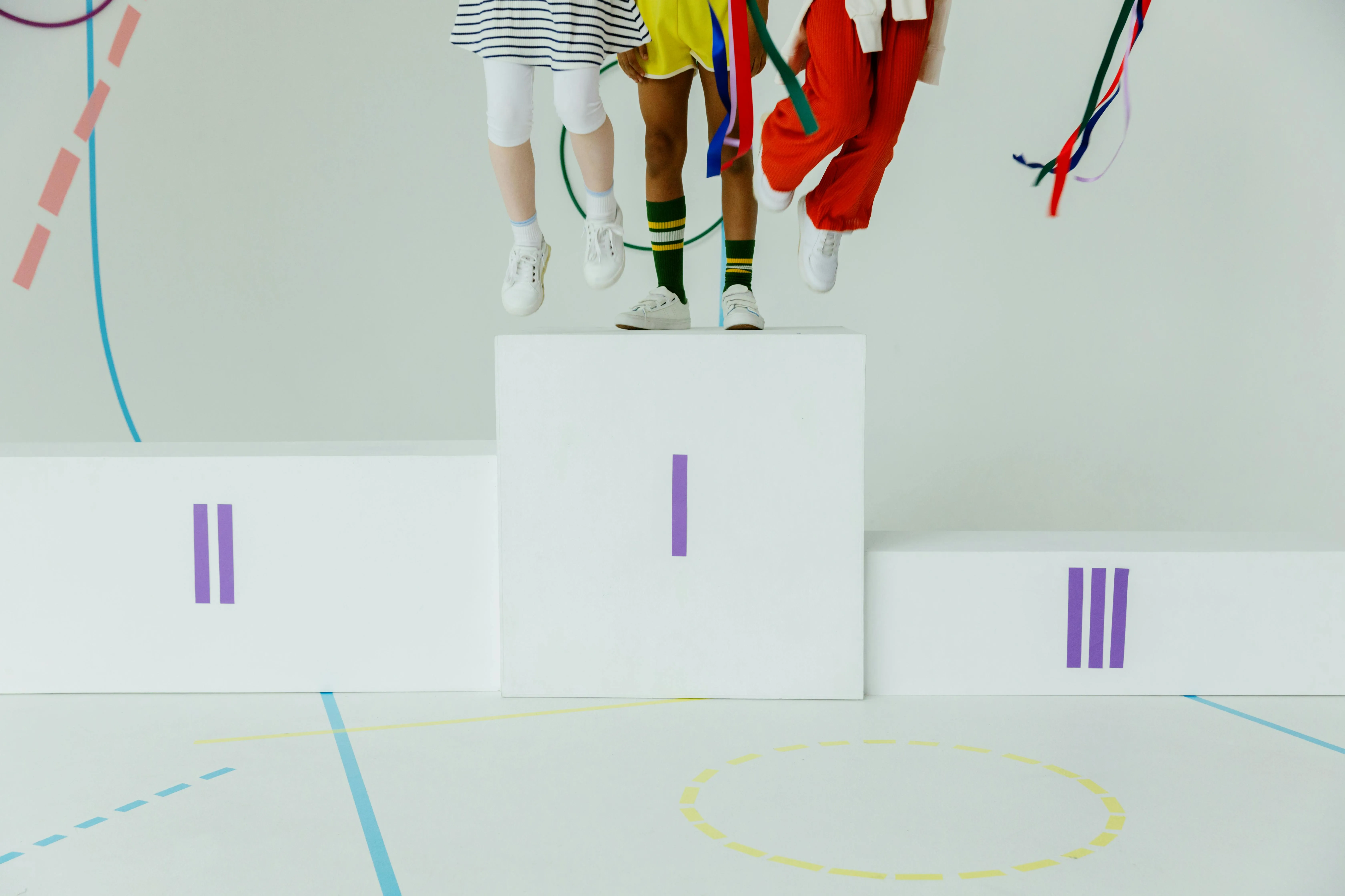 Three people standing on the number one spot on a podium