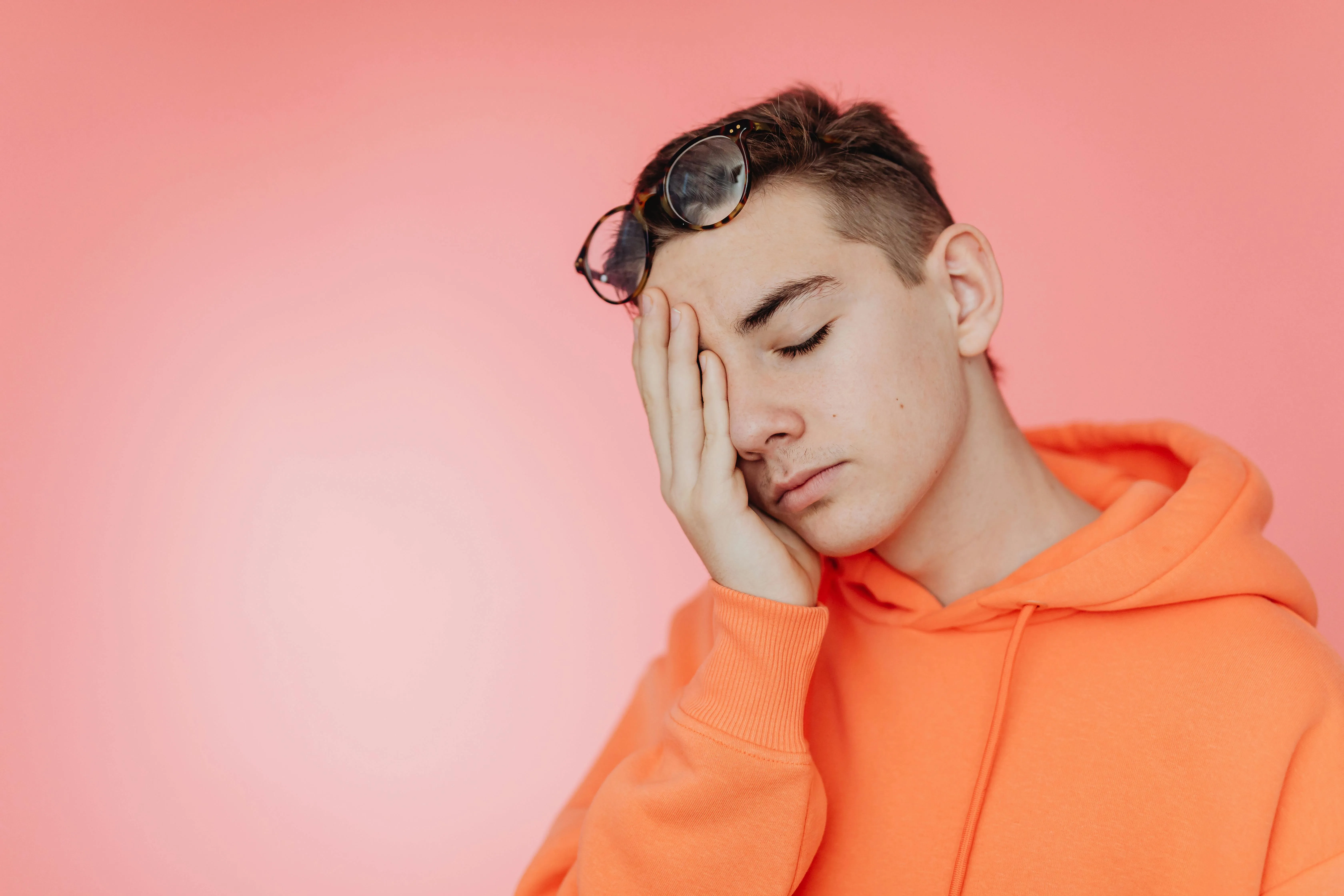 A Teenager with his head in one hand